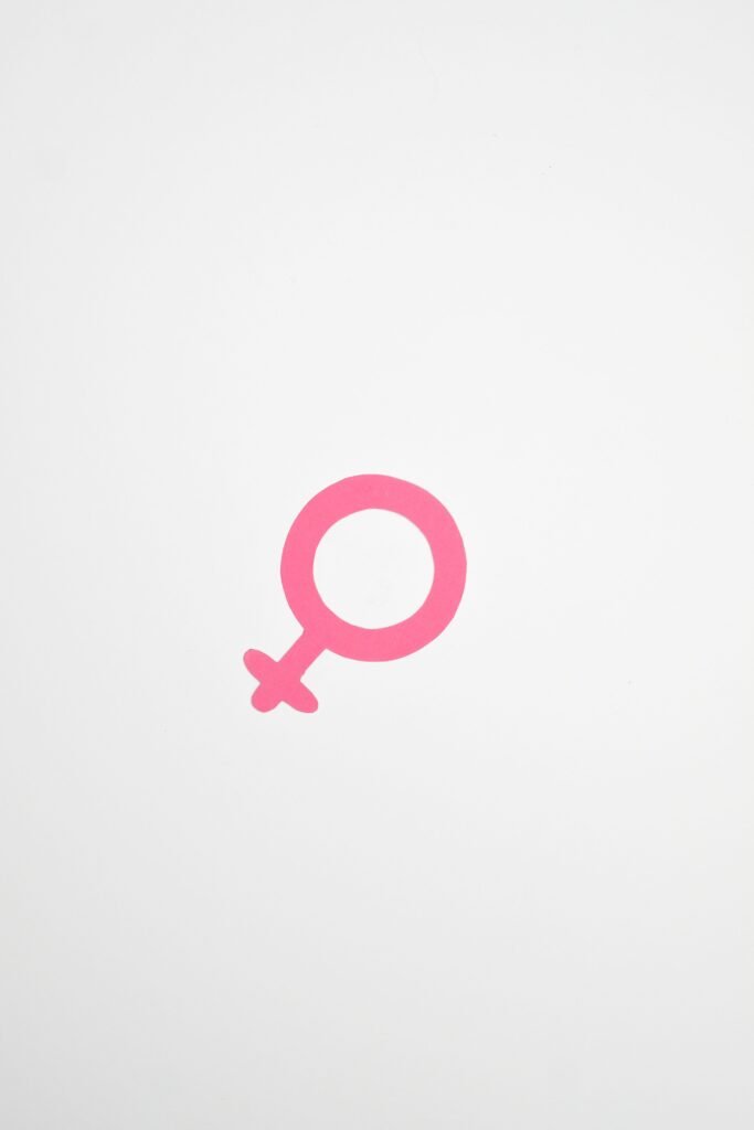 Minimalist illustration of a pink female gender symbol on a white background.